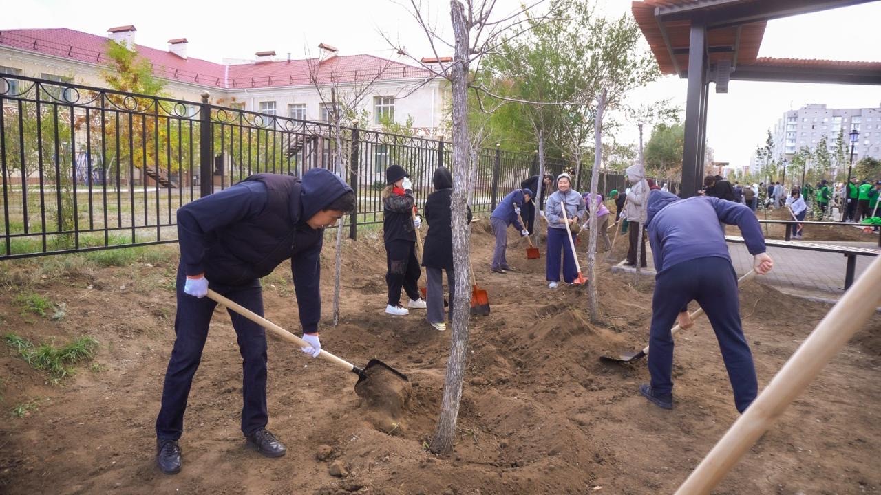 Участники акции высаживают саженцы на новой аллее в районе Сарайшык Астаны